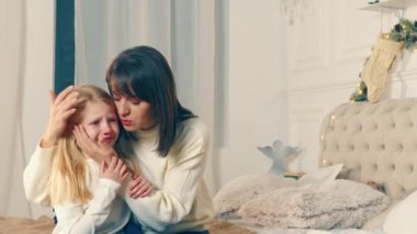 Annem ağlayan küçük bir kızı sakinleştirir. Annem Noel 'de ağlayan kızını nazikçe okşar ve ona sarılır. Küçük kız Noel gecesi ağlıyor.