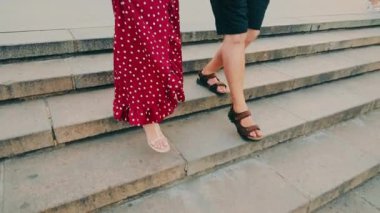 Merdivenlerden inen bir adam ve bir kadının bacakları..