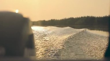 Gün batımında dalgaların üzerinde bir motorlu tekneden güzel bir manzara. Gün batımında bir motorlu tekne gezisi.