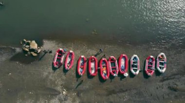Dağ nehrinin kıyısına park etmiş Rafting teknelerinin hava manzarası. Bir dağ nehrinde rafting yapmaya başla ve hazırlan..