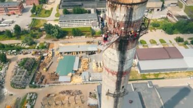 Havadan bakan adam son derece yüksek bir yerden baş aşağı atlıyor. Terk edilmiş bir fabrikanın borusundan ip atlama..