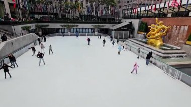 Ünlü buz pateni sahasının yüksek açılı bir çekimi, soğuk bir günde her yaştan insanı zarifçe kayarken çekiyor..