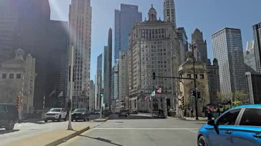 Tarihi ve modern binaları ve trafiği olan hareketli bir şehir caddesini gösteren sokak seviyesinde bir çekim..