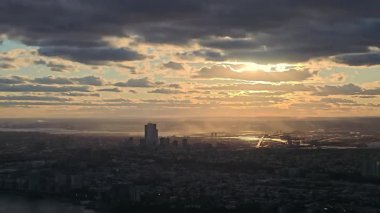 Büyüyen şehir manzarası ve sanayi manzarasının dramatik bir gökyüzü altında yükselişi.