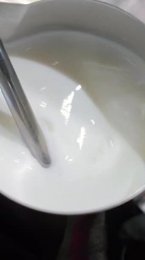 Metal bir sürahide buğulanmış süt, köpüren bir değnekle hazırlanan buğulanmış süt.