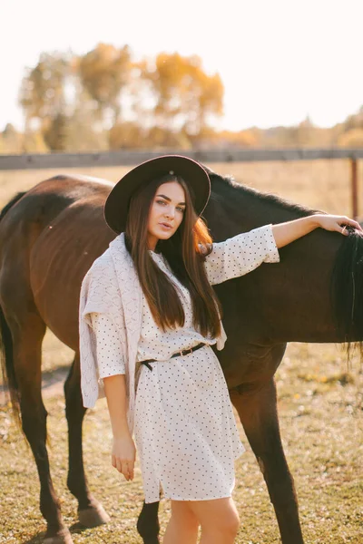 年轻美丽的模特儿戴着一顶帽子和一匹马 — 图库照片