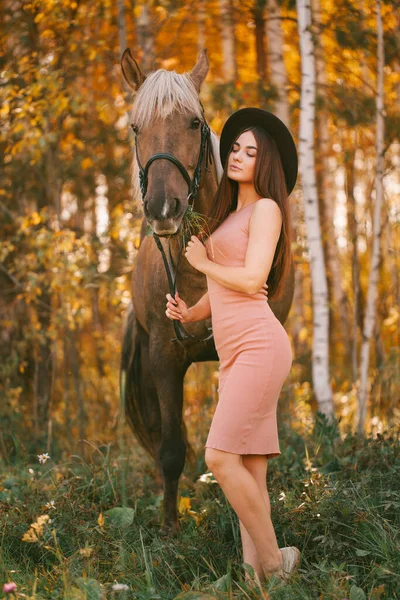 戴帽子的女孩坐在大自然中的马背上 — 图库照片