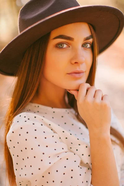 Kız parkta elbisesi ve şapkasıyla yürüyor..