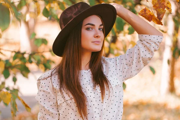 Kız parkta elbisesi ve şapkasıyla yürüyor..