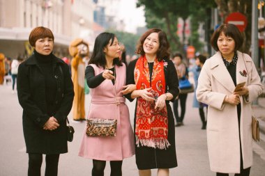 Hanoi, Vietnam. 13 Ocak 2018: Bir grup güzel kadın gün boyunca sokakta yürür ve fotoğrafçıyı fark eder.