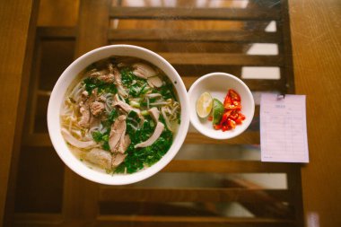 Nadir bulunan sığır eti, tendonlar, işkembe ve göğüs eti ile servis edilen bir kase ünlü Vietnamlı pho noodle çorbası. Arkaplana karşı kasıtlı olarak sığ alan derinliği