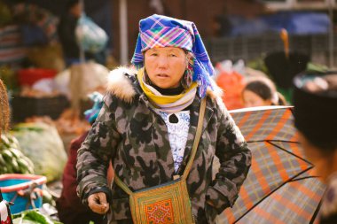 Sapa, Vietnam - 14 Ocak 2018: Geleneksel Hmong elbiseli kadın Sapa bölgesinde sokakta bir çanta ile