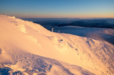 Çek Cumhuriyeti 'nde kış boyunca Krkonose dağlarında gün batımında dağ yamacında