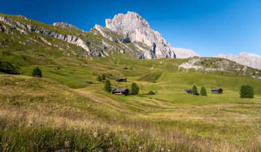 İtalya 'da Dolomitler' de Seceda Dağı 'nın altında çayır ve kulübeler