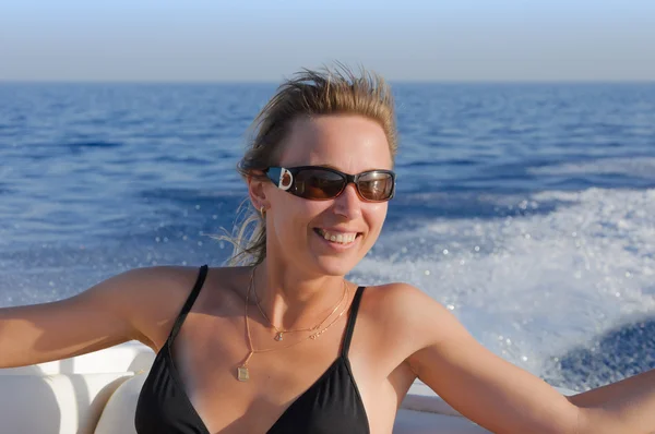 Attraente ragazza sorridente che naviga su uno yacht verso il tramonto — Foto Stock