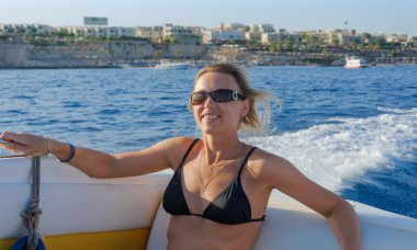 Çekici gülümseyen kız batımına bir yatta yelken