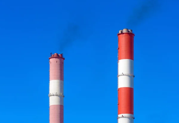Pfeifen rauchendes Wärmekraftwerk vor blauem Himmel — Stockfoto