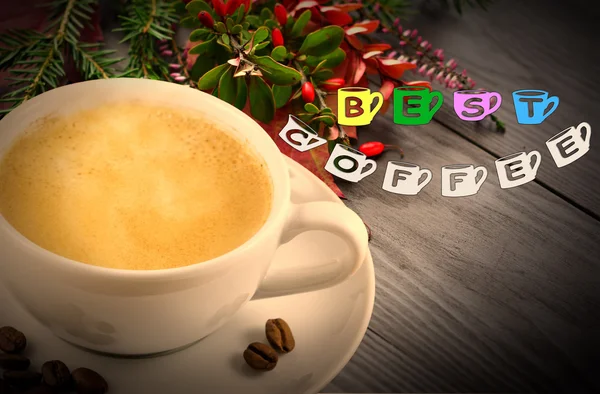 Best coffee sign and coffee cup on a blackboard on a wooden background