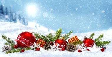 Şenlikli Noel kompozisyonu. Kırmızı Noel baloları, hediye kutuları, koniler kar taneleri ve köknar dalları ile süslenmiş mavi kış karlı zemin üzerinde fotokopi alanı ile.