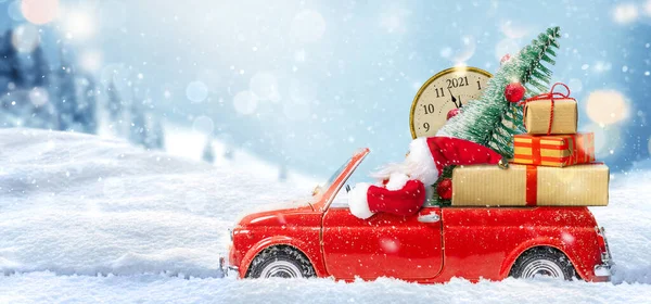 Noël arrive. Père Noël en voiture jouet rouge livrant des cadeaux pour le Nouvel An 2021 — Photo