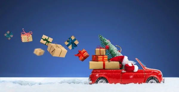 Babbo Natale in auto rossa consegna Natale o Capodanno scatole regalo su uno sfondo blu innevato. — Foto Stock