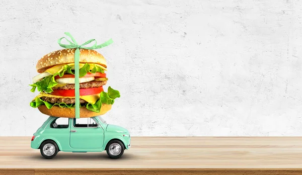 Retro toy car delivering fast food order on wooden table. Copy space — Stock Photo, Image