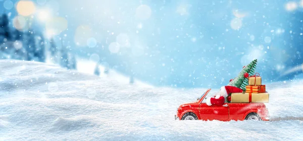 赤い車のサンタクロースは雪の背景でクリスマスツリーと贈り物を提供します。クリスマスカード — ストック写真