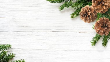 Beyaz ahşap arka planda Noel ağacı dalları ve çam kozalakları