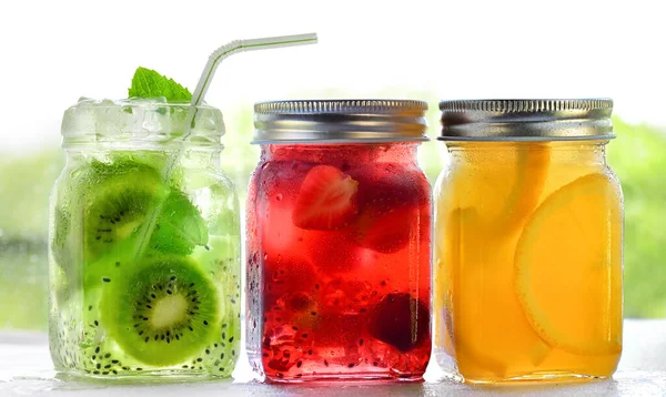 Bright Colorful refreshing summer drinks in glass jars with ice on white background — Stockfoto