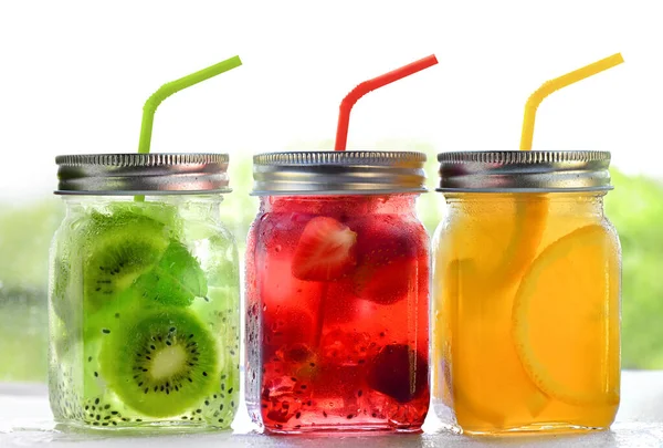 Bunte erfrischende Sommergetränke in Glasgefäßen mit Deckel und Strohhalmen auf weißem Hintergrund — Stockfoto