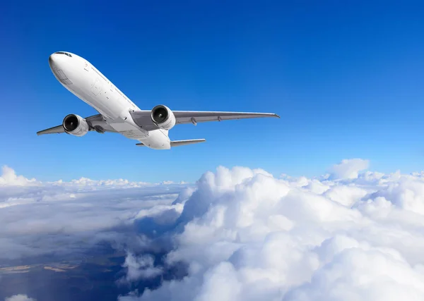 Flugzeug fliegt über Wolken auf blauem Himmel Hintergrund — Stockfoto