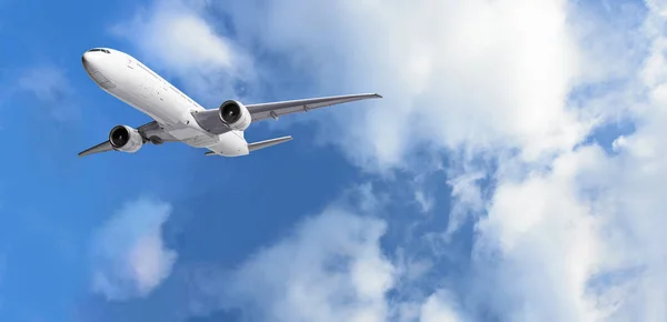 푸른 하늘 배경으로 구름 위를 날고 있는 비행기 — 스톡 사진