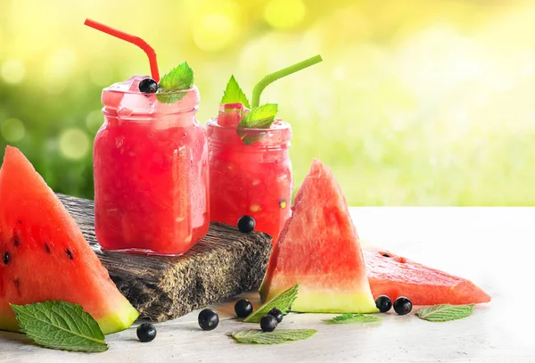 Frischer Wassermelonen-Smoothie im Glas, Wassermelonenscheiben auf dem Holztisch. — Stockfoto