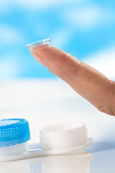 Contact lens on finger tip  blue background — Stock Photo, Image