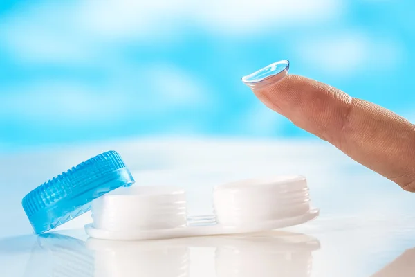 Contact lens on finger tip  blue background — Stock Photo, Image