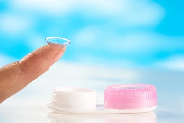 Contact lens on finger tip  blue background — Stock Photo, Image