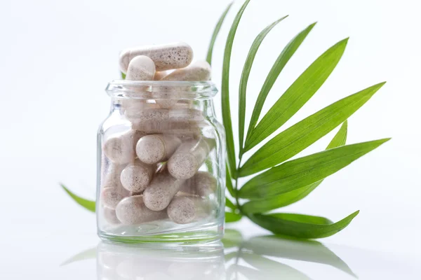 Kapsułki leku ziołowego w szklanej butelce z zielonej l Medycyna alternatywna koncepcja. — Zdjęcie stockowe