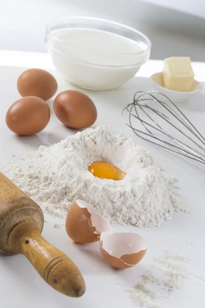 Яйца, мука, молоко, масло и кухонная утварь — стоковое фото