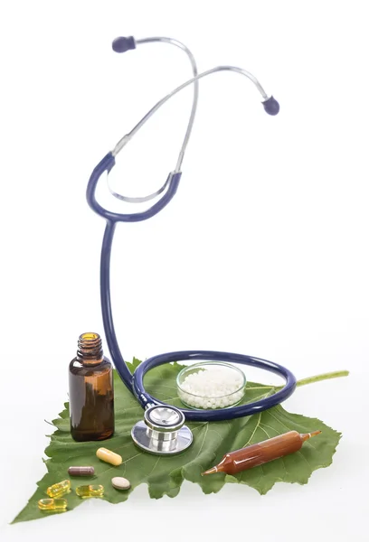 Medicina alternativa hierbas y estetoscopio en la hoja — Foto de Stock