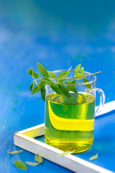 Citronová verbena Bylinkový čaj ve skleněném šálku. Aloysia citriodora. Naturopatie. DřevoPozadí. — Stock fotografie