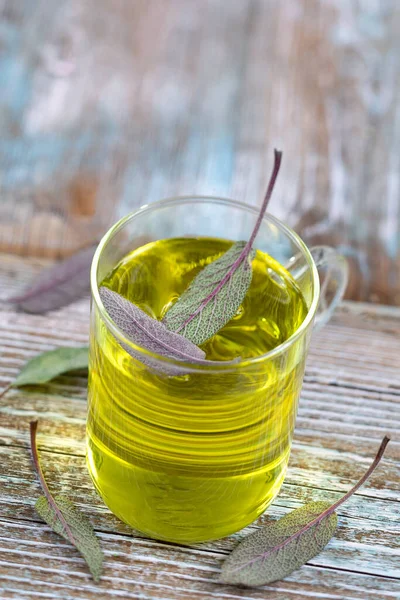 Cup av växtbaserade salvia te med färska blad på rustik bakgrund, hälsa koncept, närbild — Stockfoto