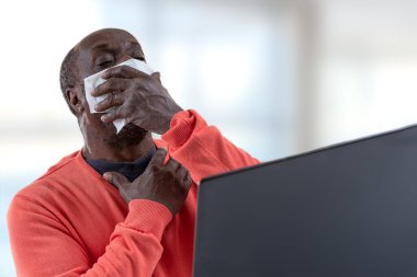 Teletıp konsepti - Siyah erkek hasta web kamerasından konuşarak sağlık durumunu doktora danışıyor ve ateşi var