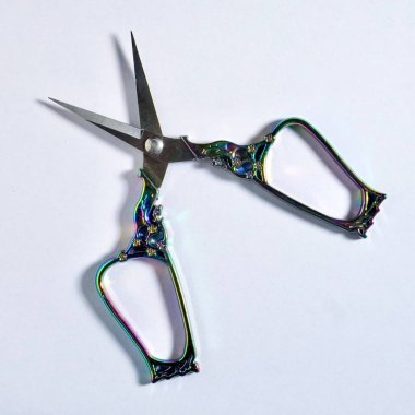 Beyaz arkaplanda izole edilmiş süslü metal saplı açık makas.