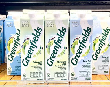 Jakarta, Endonezya - 25 Şubat 2026 - Greenfields markası yağsız ve düşük yağlı süt karton ambalajı yatay buzdolabı raf arka planında izole.