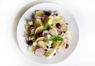 Hindiba, haşlanmış yumurta, turp, soğan, zeytin, limon ve beyaz arka planda izole edilmiş ayçekirdeği ile taze salata. Sağlıklı gıda konsepti.