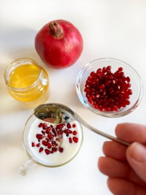Kefir ya da yoğurt, beyaz ahşap arka planda nar ve bal. Sağlıklı gıda konsepti. Genel Görünüm.