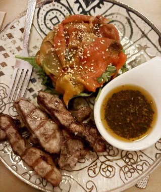 Izgara et, susam tohumlu kavrulmuş kırmızı biber ve yağ ve baharattan yapılmış bir kase sos. Genel Görünüm.