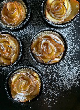Ev yapımı elmalı güller puf böreği ve siyah arka planda krema serpiştirilmiş şeker. Ev yapımı. Genel Görünüm.