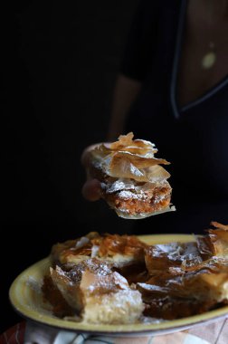 Siyah arka planda fillo hamurlu balkabağı turtası. Cadılar Bayramı ve Sonbahar Şenlikleri. Yakın plan..