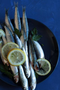 Mavi arka planda taze çiğ sardalya ve limon. Akdeniz yemekleri. Genel Görünüm.